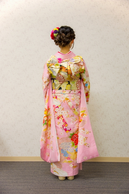 a photo of the back of a young woman wearing traditional Japanese clothing